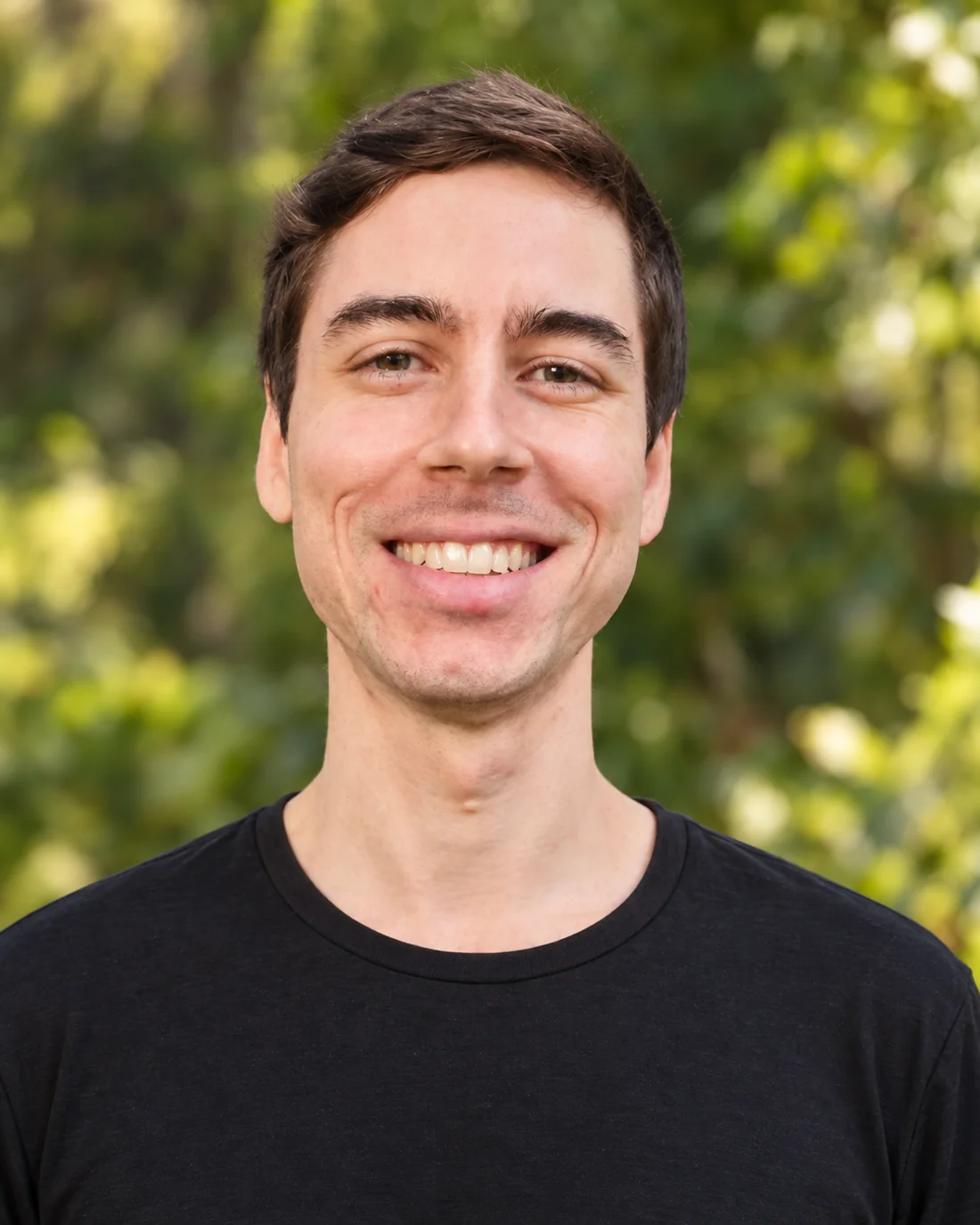 Paulo Cenacchi sorrindo em um retrato ao ar livre